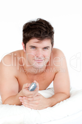 man on his bed and holding a remote