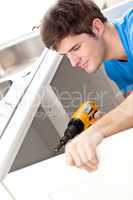 man holding a drill repairing kitchen