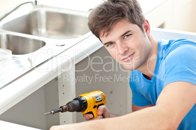 man holding a drill repairing kitchen