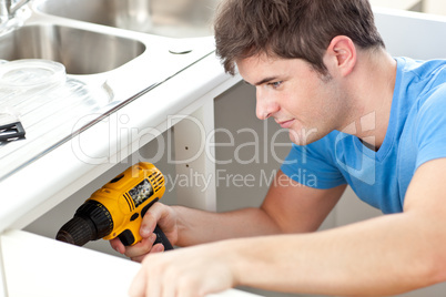 man holding a drill repairing kitchen