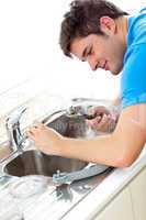 man repairing a kitchen sink at home