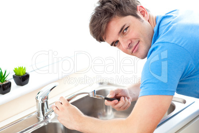 Young man repairing a kitchen sink