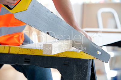 male worker sawing a wooden board