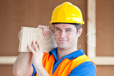 male worker carrying a wooden board