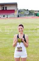 Happy female athlete holding a trophy