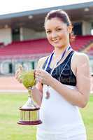 Joyful female athlete holding a trophy