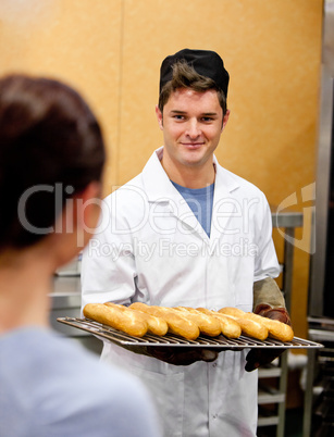 male baker holding baguettes