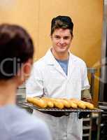 male baker holding baguettes