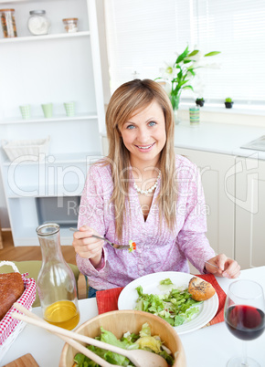 woman eating salad in the kitchen