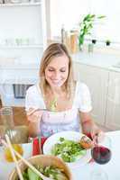 Cute woman eating salad in the kitchen