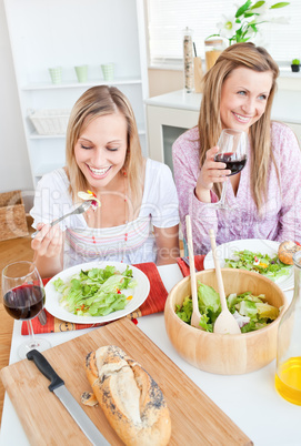 female friends eating salad in the kitchen