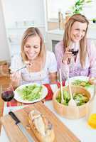 female friends eating salad in the kitchen