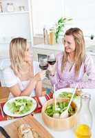 female friends eating salad in the kitchen