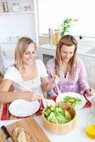 Two female friends eating salad