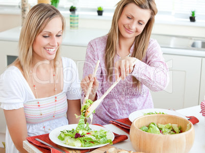 women eating salad in the kitchen