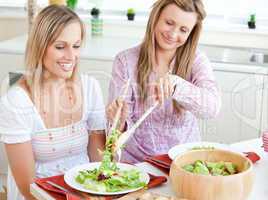 women eating salad in the kitchen
