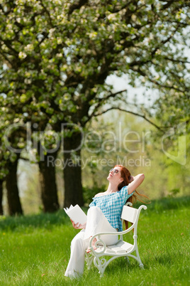 Young woman relaxing under blossom tree in spring