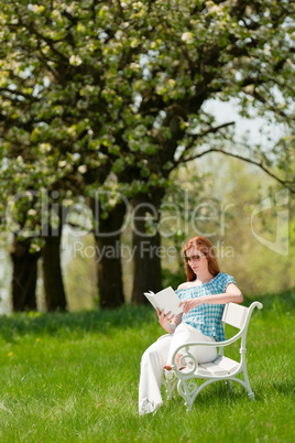 Young woman relaxing under blossom tree in spring