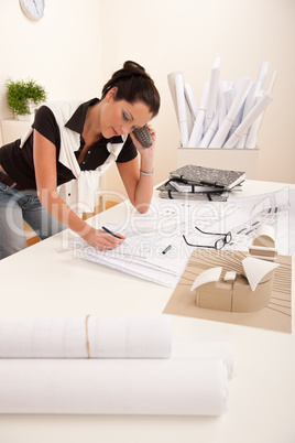 Female architect busy at the office calling