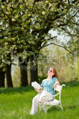 Young woman relaxing under blossom tree in spring