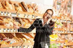 Grocery store: Business woman with mobile phone