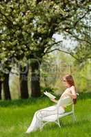 Young woman relaxing under blossom tree in spring