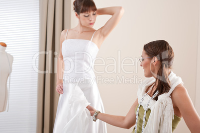 Fashion model fitting white wedding dress by designer