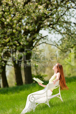 Young woman relaxing under blossom tree in spring