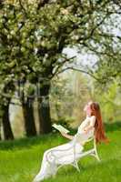Young woman relaxing under blossom tree in spring