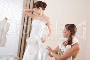 Fashion model fitting white wedding dress by designer