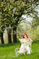 Young woman relaxing under blossom tree in spring