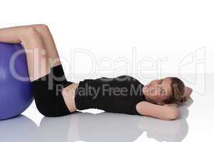 Fitness - Young woman with exercise ball on white