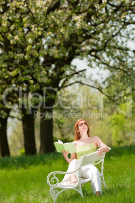 Young woman relaxing under blossom tree in spring