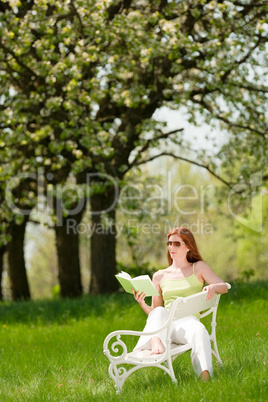 Young woman relaxing under blossom tree in spring