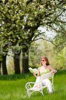 Young woman relaxing under blossom tree in spring