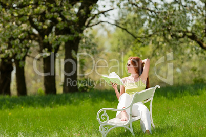 Young woman relaxing under blossom tree in spring