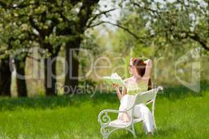 Young woman relaxing under blossom tree in spring