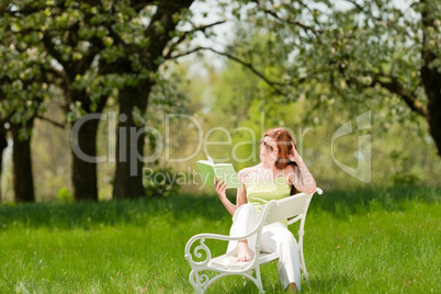 Young woman relaxing under blossom tree in spring