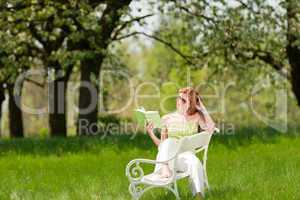 Young woman relaxing under blossom tree in spring