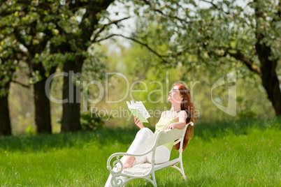 Young woman relaxing under blossom tree in spring