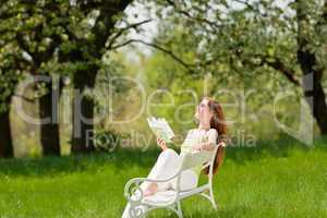 Young woman relaxing under blossom tree in spring