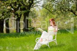 Young woman relaxing under blossom tree in spring