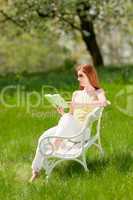 Young woman relaxing under blossom tree in spring