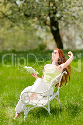 Young woman relaxing under blossom tree in spring