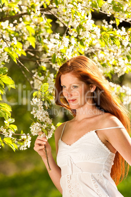 Young woman enjoying spring under blossom tree