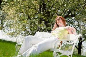 Young woman relaxing under blossom tree in spring