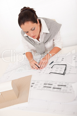 Attractive female architect watching plans