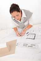 Attractive female architect watching plans