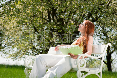 Young woman relaxing under blossom tree in spring