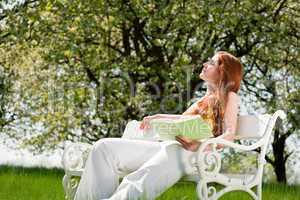 Young woman relaxing under blossom tree in spring